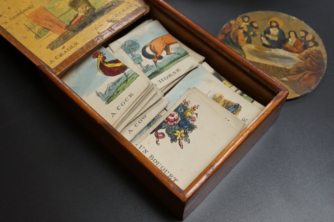 A Victorian Papier mache japanned sewing box, stamped ‘Lane, Birmingham’, the cover with a view of Chingford old church Essex, a boxed Victorian French translation game, by E C Spurin and a papier mache panel (3)
